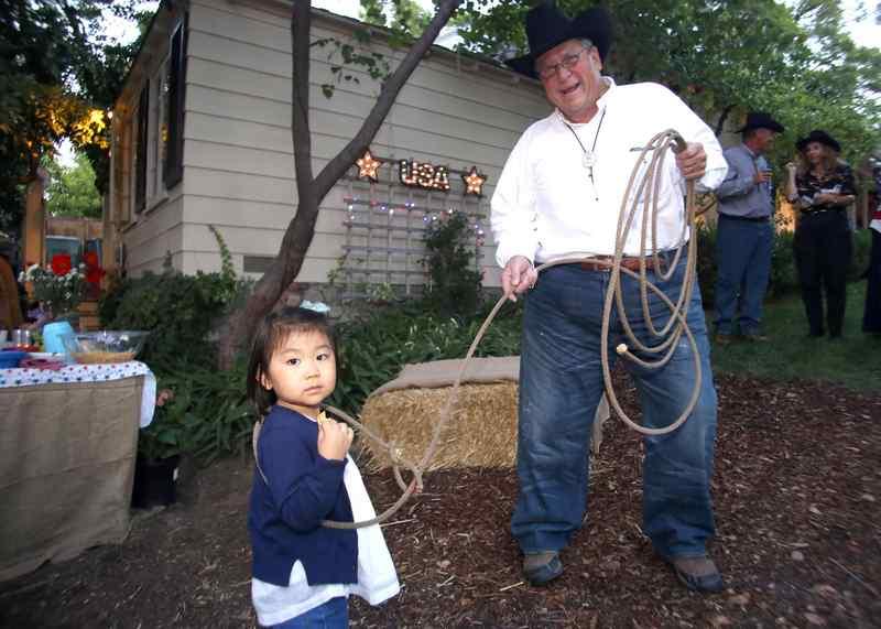 Fulton Haight “lassos” Olivia Liu, 3, during the Texas barbecue. (Photo by James Carbone)